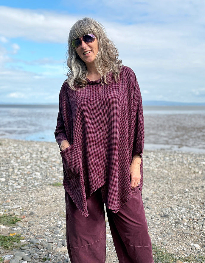 woman wearing oversized purple burgundy tunic and lantern shaped trousers