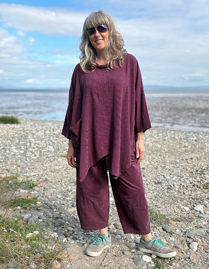 woman wearing oversized purple burgundy tunic and lantern shaped trousers