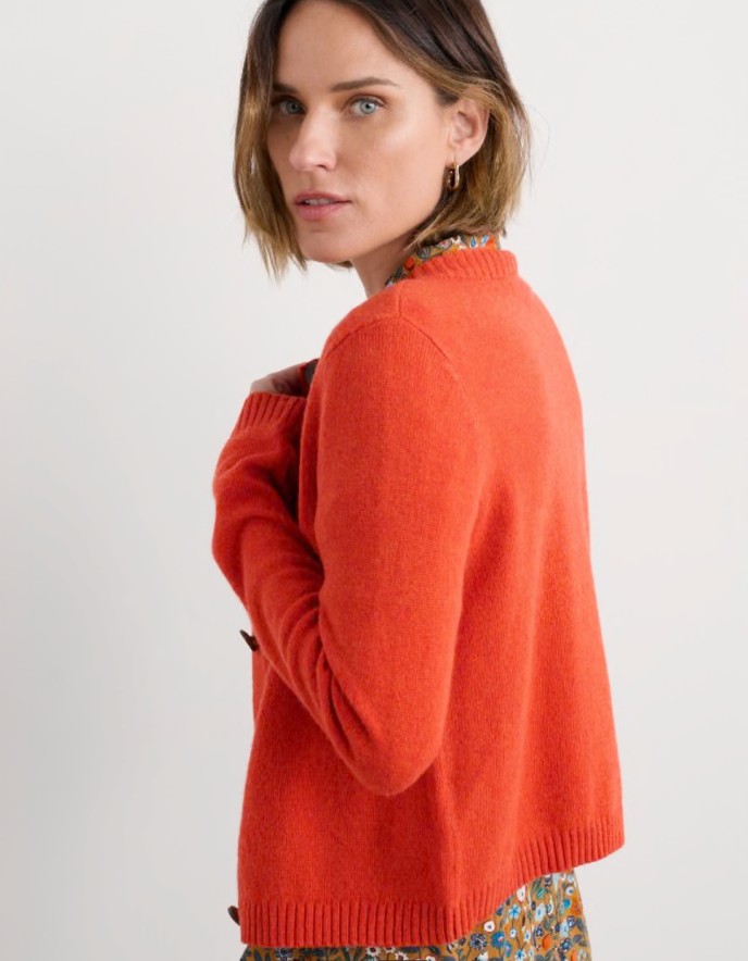 Woman wearing an orange sweater on a white background