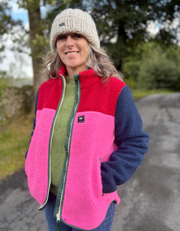 Person wearing a colorful fleece vest and hat outdoors
