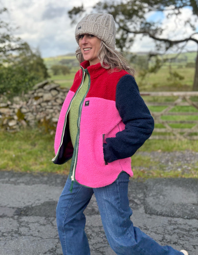 Person wearing a colorful jacket and hat in a natural setting