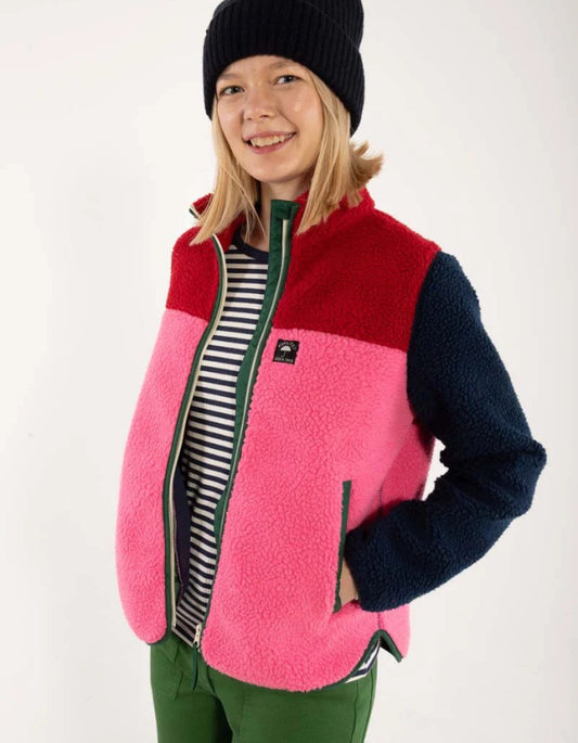 Child wearing a colorful fleece vest with a white background