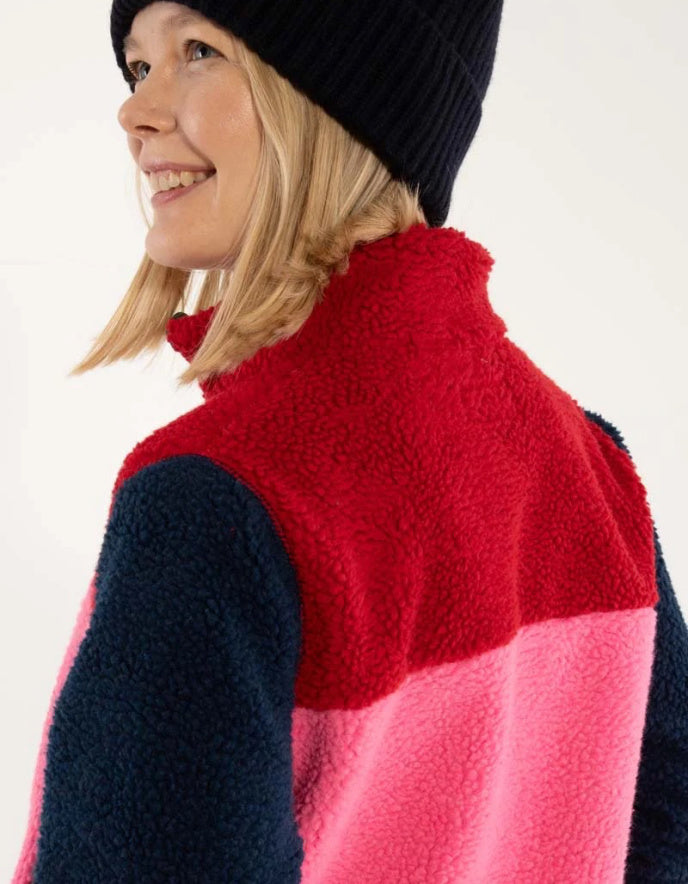 Person wearing a colorful fleece vest with a white background