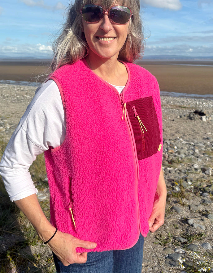 Person wearing a bright pink vest on a beach