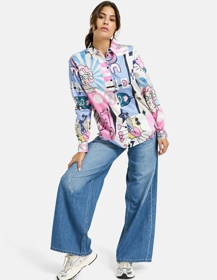 Person wearing a colorful patterned shirt and blue jeans on a white background