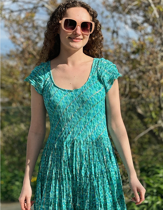 turquoise summer dress with capped sleeves and scoop neckline and full skirt, features moon print with gold thread running through