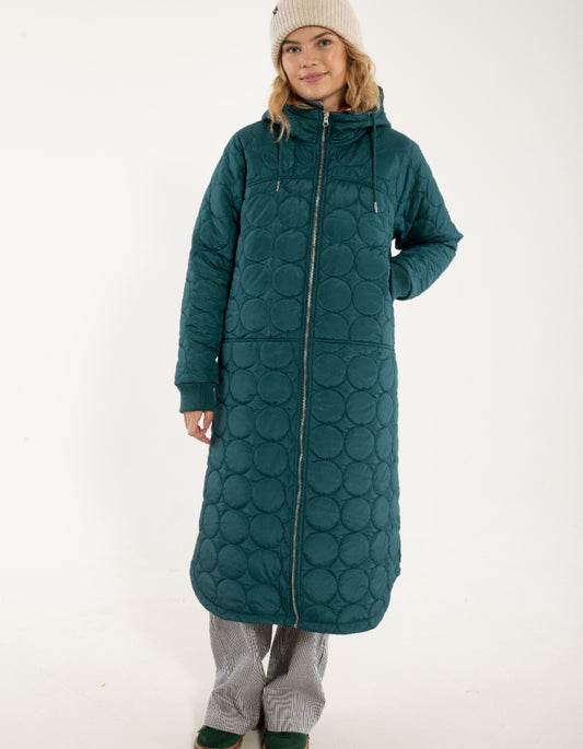 Person wearing a long teal quilted coat on a white background