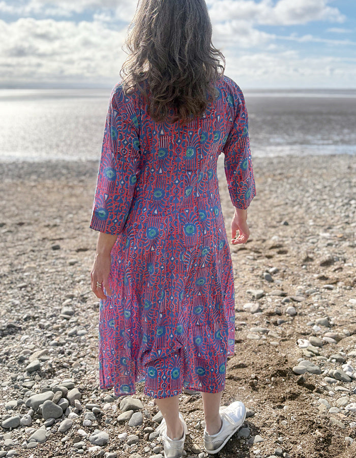midi length cotton dress with full skirt and pockets and 3/4 length sleeves and V neckline in red and blue hand blocked print
