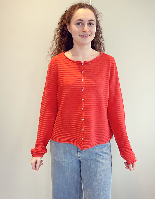 short wide boxy cardigan with ribbed texture, long sleeves and scoop neck in coral