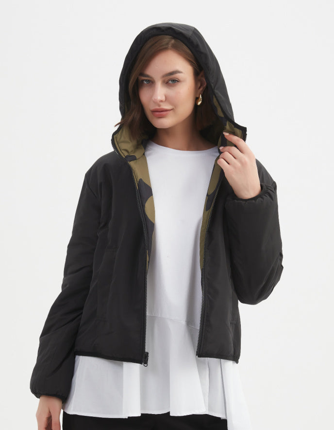 Woman wearing a camouflage olive and black reversible puffer jacket on a white background