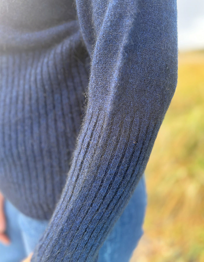 Close-up of a textured blue sleeve with a blurred natural background