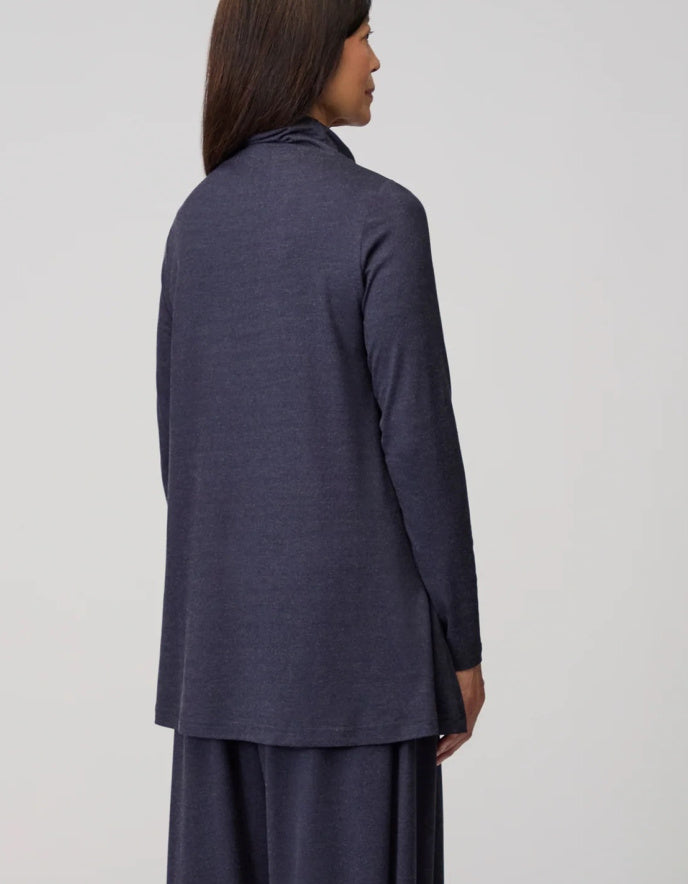 Person wearing a long dark blue jacket on a light gray background
