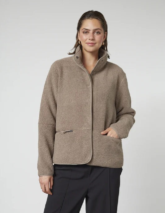 Woman wearing a beige fleece jacket on a white background