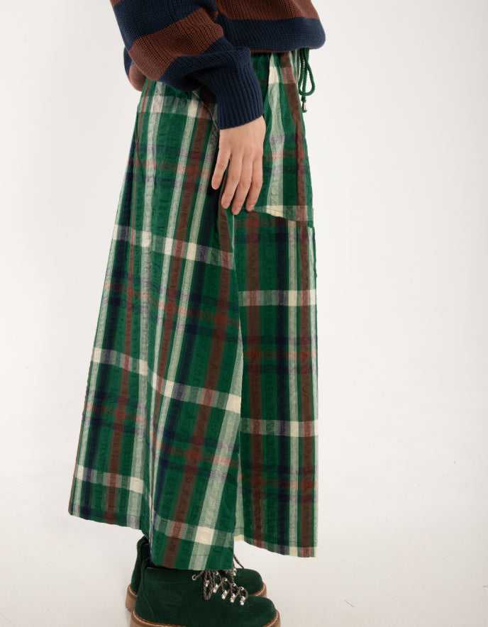 Green plaid pants worn by a person on a white background