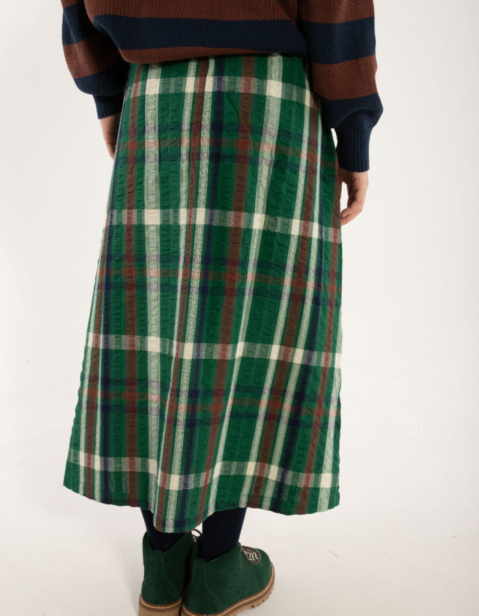 Person wearing a green plaid skirt on a white background