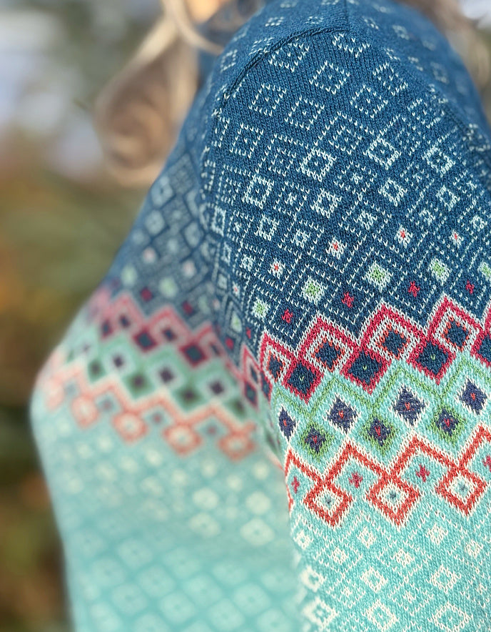 Close-up of a knitted fabric with geometric pattern in blue, green, and red.