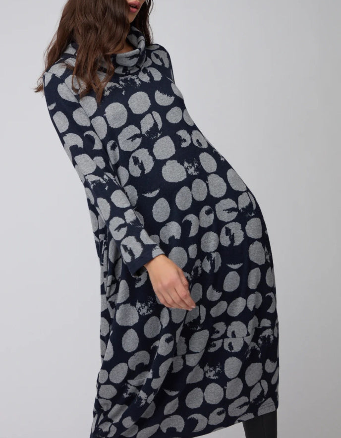 Navy blue dress with white abstract pattern worn by a person on a light gray background