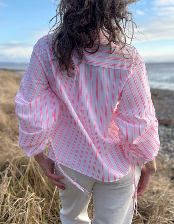 woman wearing cotton pink pion striped shirt with gathered sleeves and cream cropped jeans