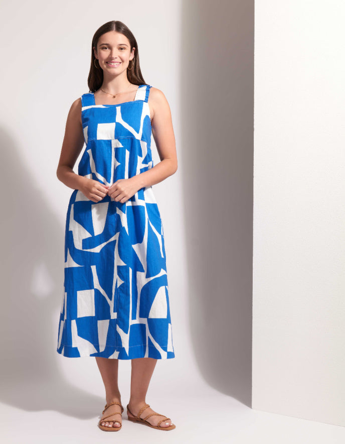Woman wearing a blue and white patterned dress against a plain background