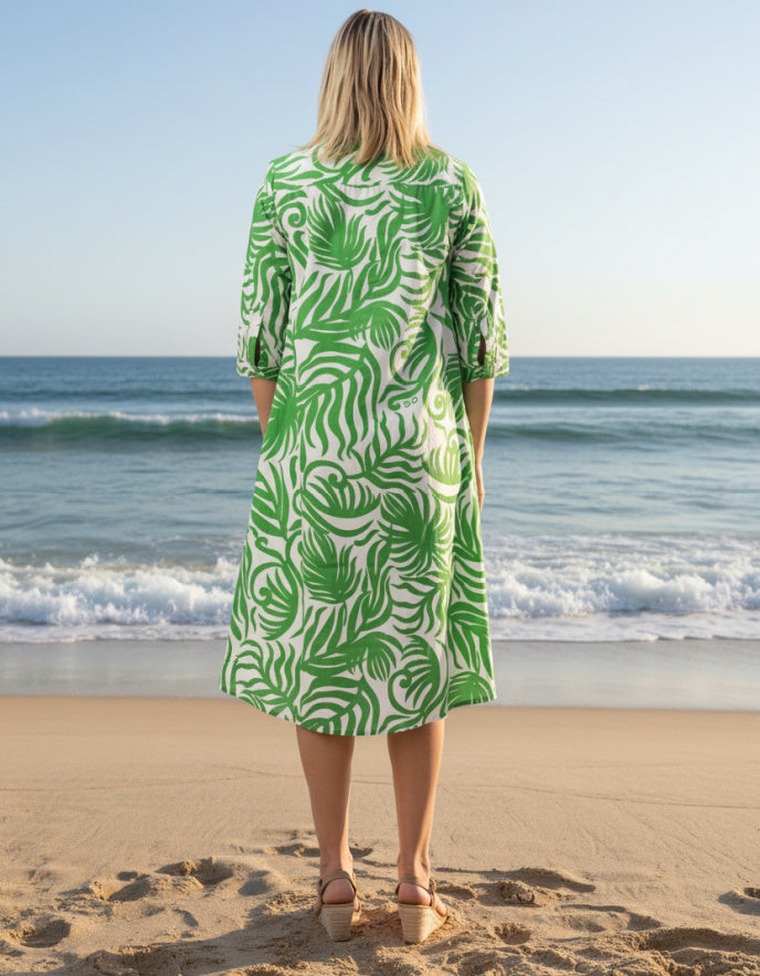 woman wearing green and white shirt dress on a beach
