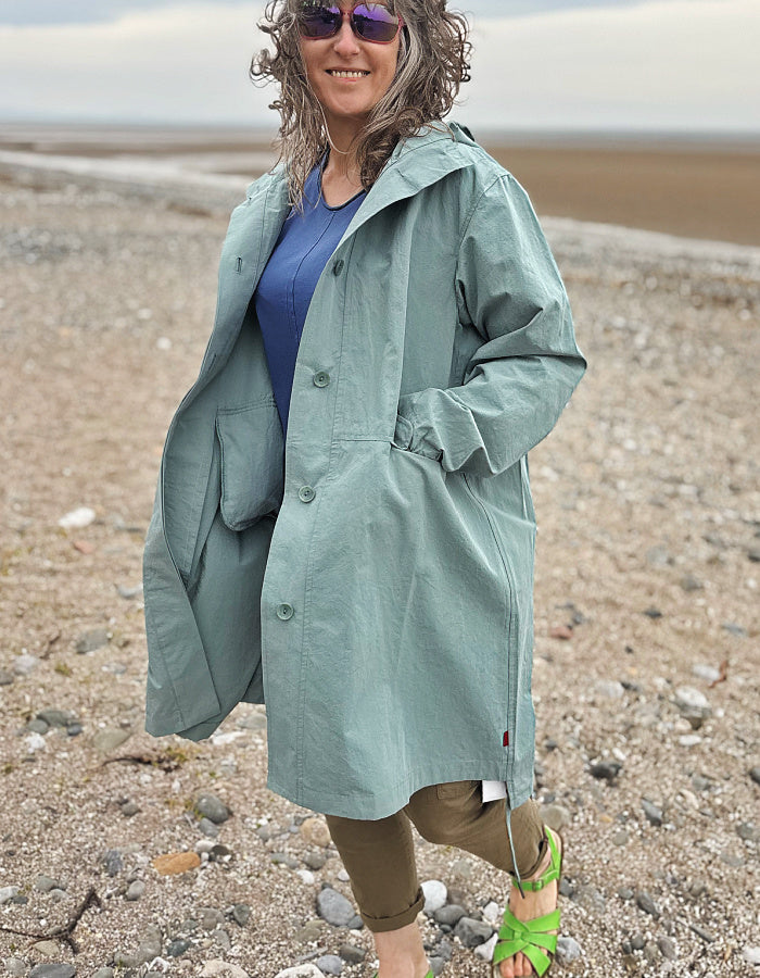 cotton hooded duster coat in soft duck egg blue, two front pockets and button front and pleated back for a swing shape