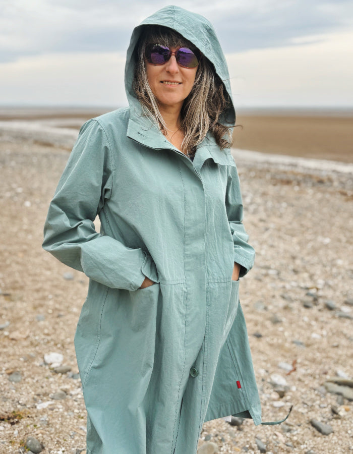 cotton hooded duster coat in soft duck egg blue, two front pockets and button front and pleated back for a swing shape