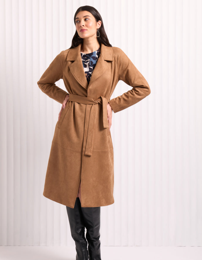 Woman wearing a brown coat against a white background