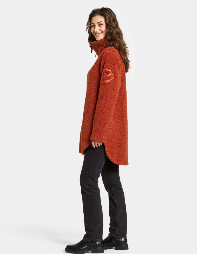Woman wearing a rust orange sherpa pile fleece jacket on a white background