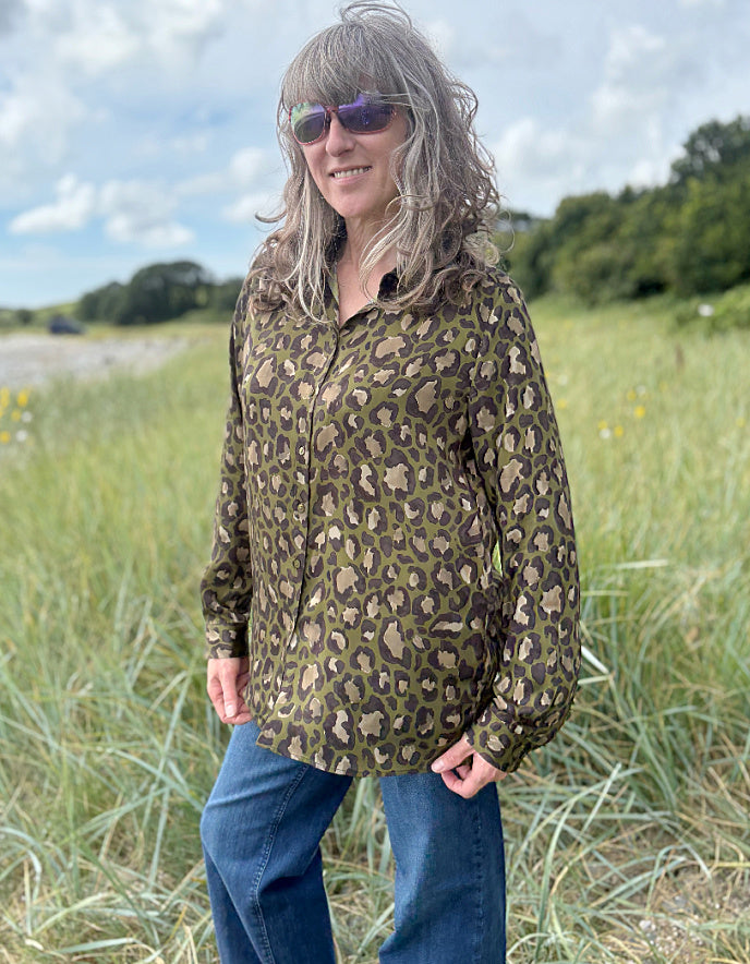 Person wearing a leopard print shirt in a field