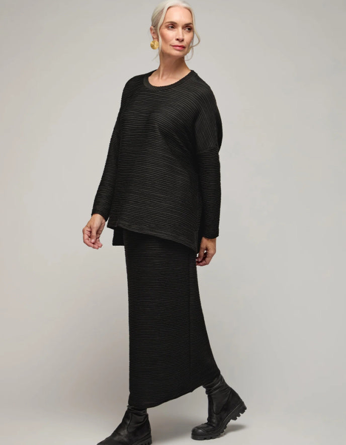 Woman wearing a black outfit on a plain background