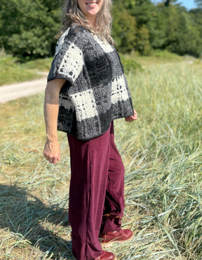 Person wearing a checkered poncho in a field