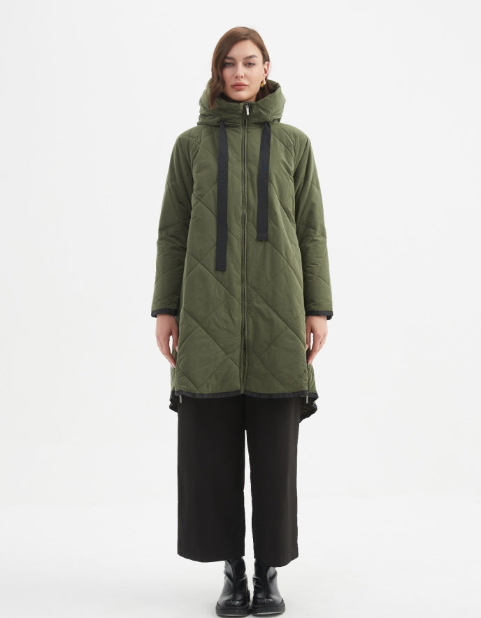 Person wearing a green quilted coat on a white background