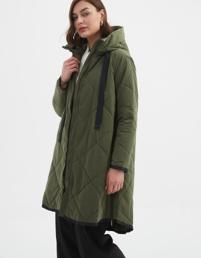 Woman wearing a green quilted jacket on a white background