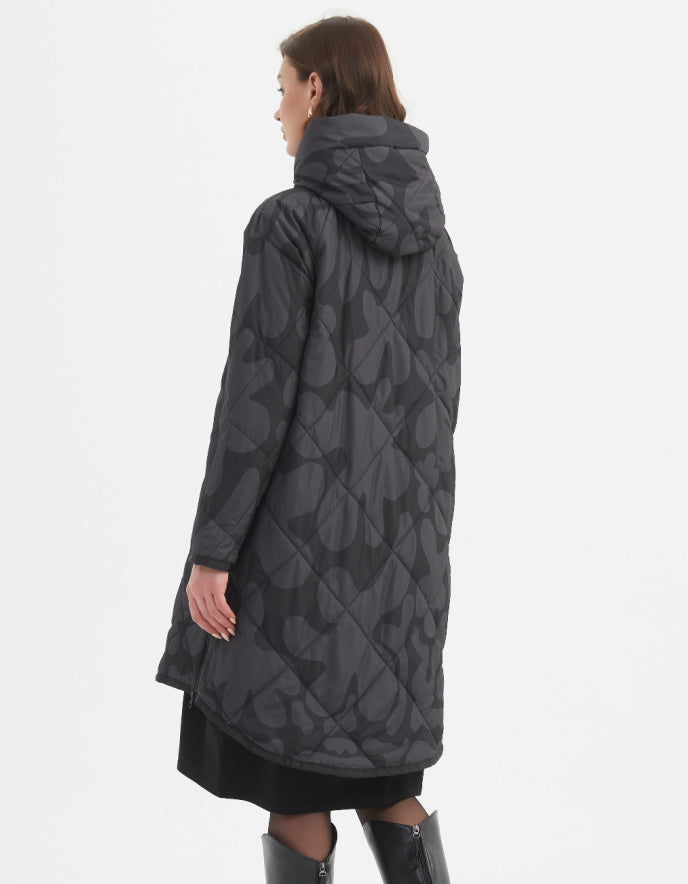 Woman wearing a long dark gray coat with a pattern on a white background