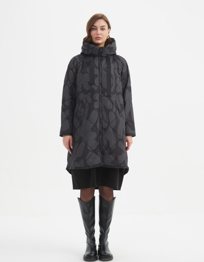 Woman wearing a long dark coat with a pattern on a white background
