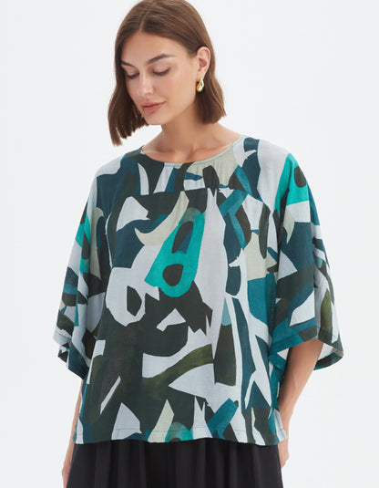 Woman wearing a colorful abstract patterned top on a white background