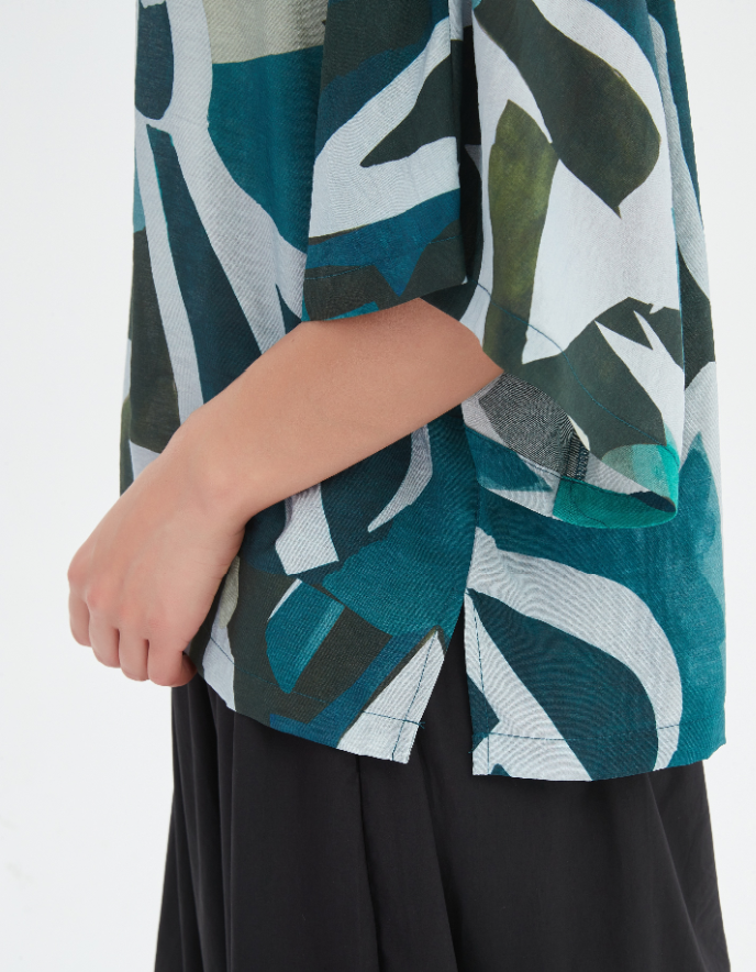 Close-up of a person wearing a green and black patterned jacket with a white background