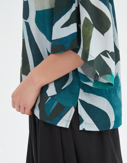 Close-up of a person wearing a green and black patterned jacket with a white background