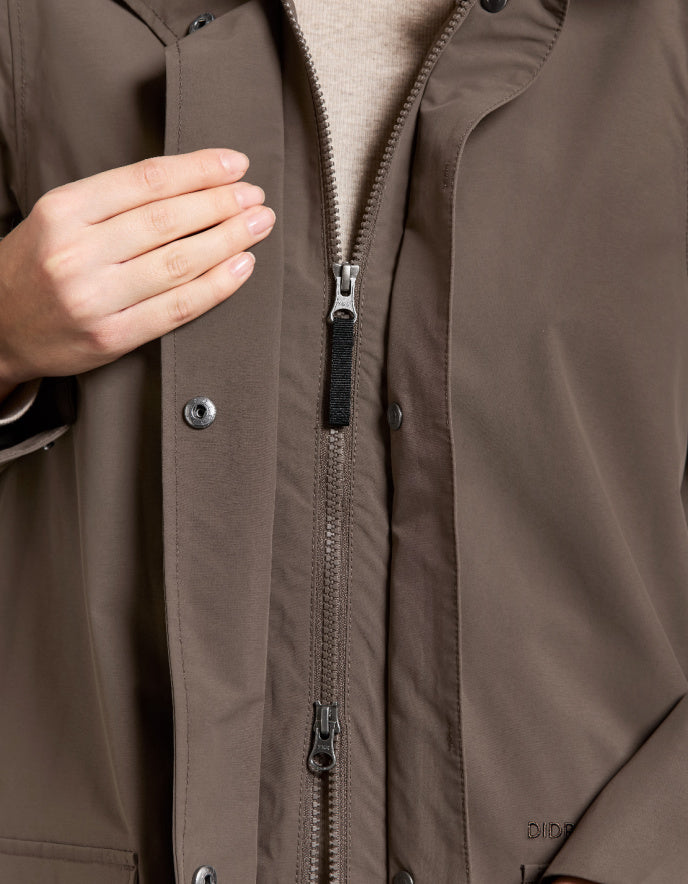 Close-up of a brown jacket with a zipper and button details.