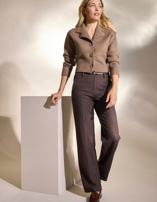 Brown pin stripe pants worn by a person on a white background