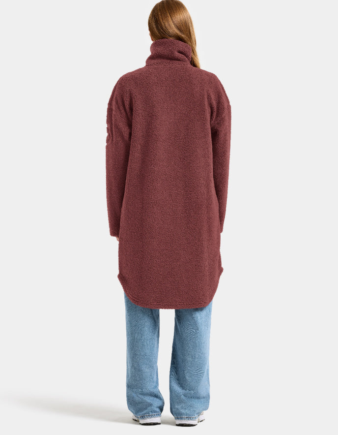Woman wearing a long burgundy fleece sherpa pile coat on a white background jacket