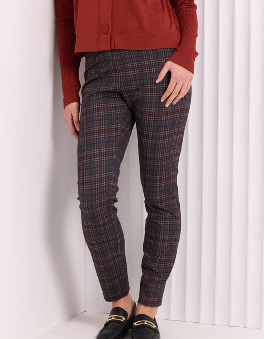 Person wearing plaid pants and a red top against a white background
