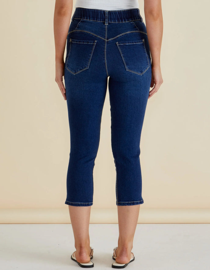 Person wearing blue jeans on a beige background