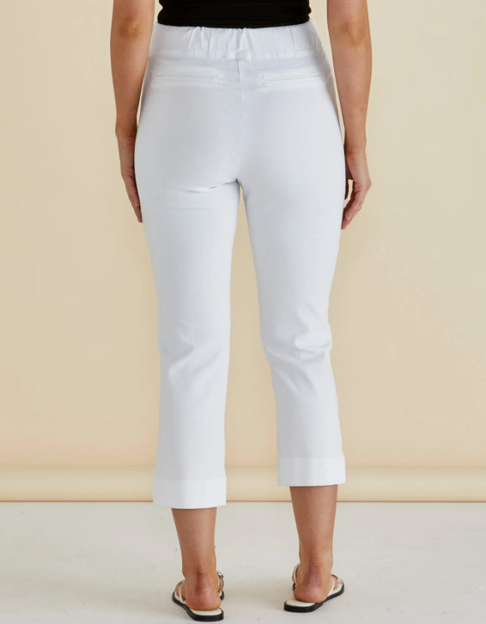 Person wearing white pants against a beige background