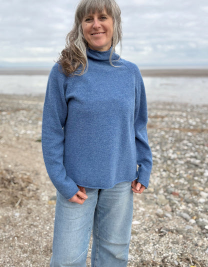 woman wearing lambswool merino turtle neck sweater in denim blue