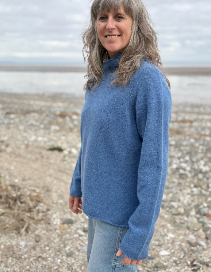 woman wearing lambswool merino turtle neck sweater in denim blue