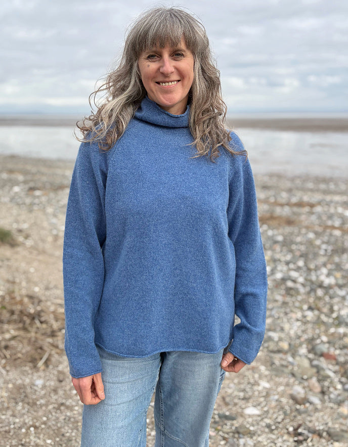 woman wearing lambswool merino turtle neck sweater in denim blue