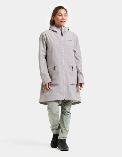Person wearing a gray raincoat and pants on a white background