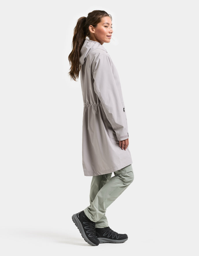 woman wearing pale pink raincoat