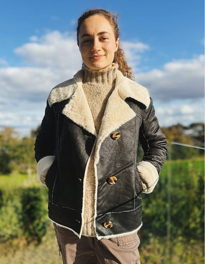 girl wearing black faux leather jacket with furry lining outside 